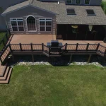Custom backyard deck with white vinyl railings